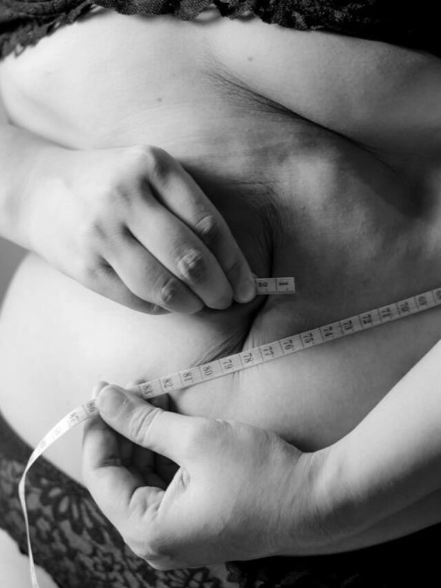 pessoa com uma fita métrica em volta na barriga