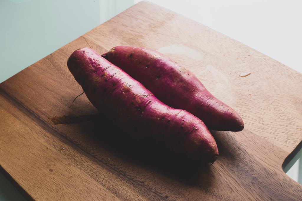imagem de duas batata doce em uma tábua de cozinha