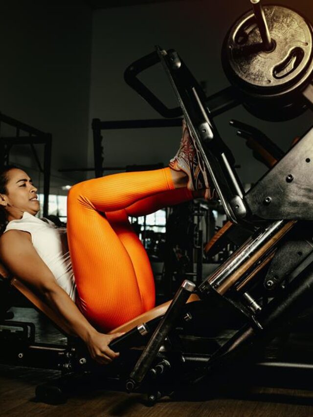 mulher fazendo leg press na academia