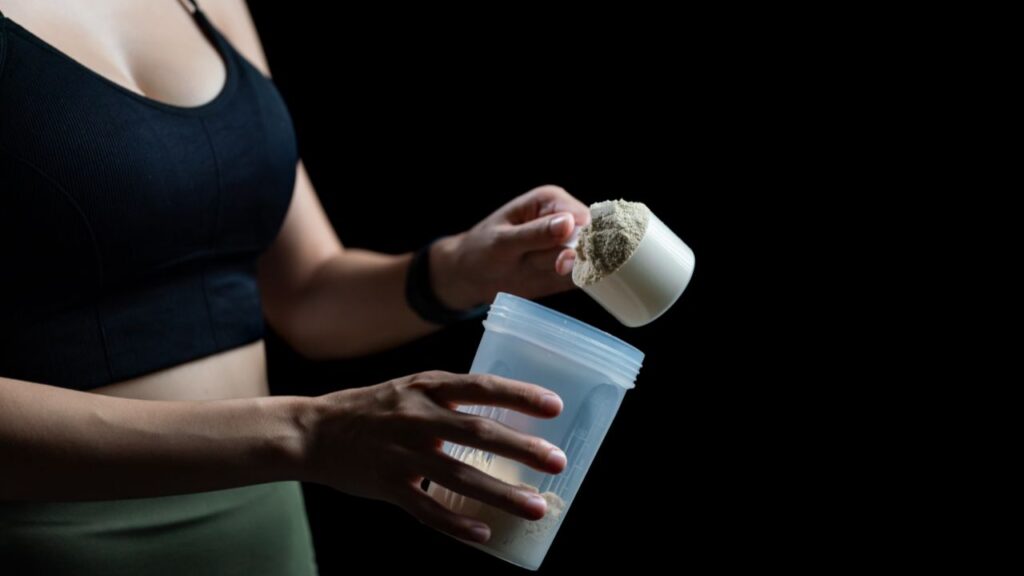 atleta adicionando uma porção de whey protein para tomar junto com carboidratos.