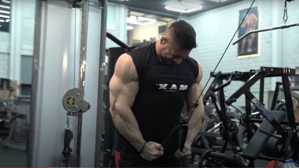 Atleta da Max Titanium, Ramon Dino, treinando realizando exercício de triceps polia
