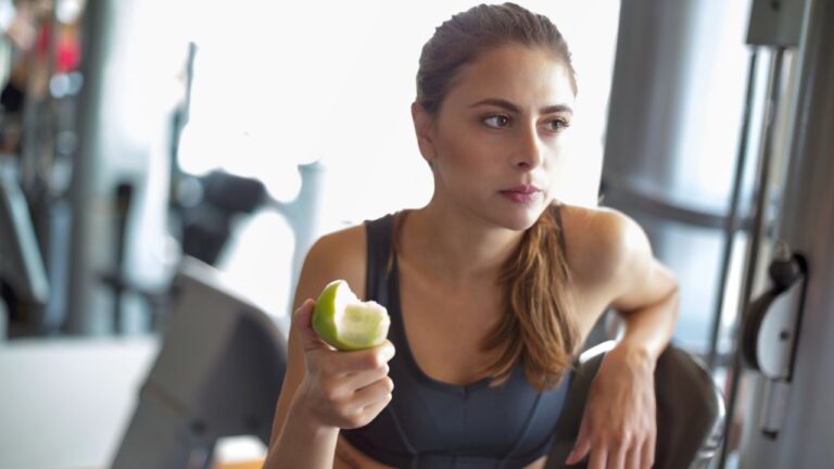atleta comendo maça entre apos o treino